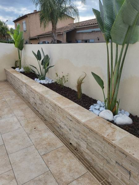 Plantation de différents végétaux dans une jardinière extérieure