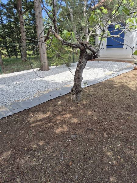 Recouvrement d'un sol avec géotextiles et graviers blancs